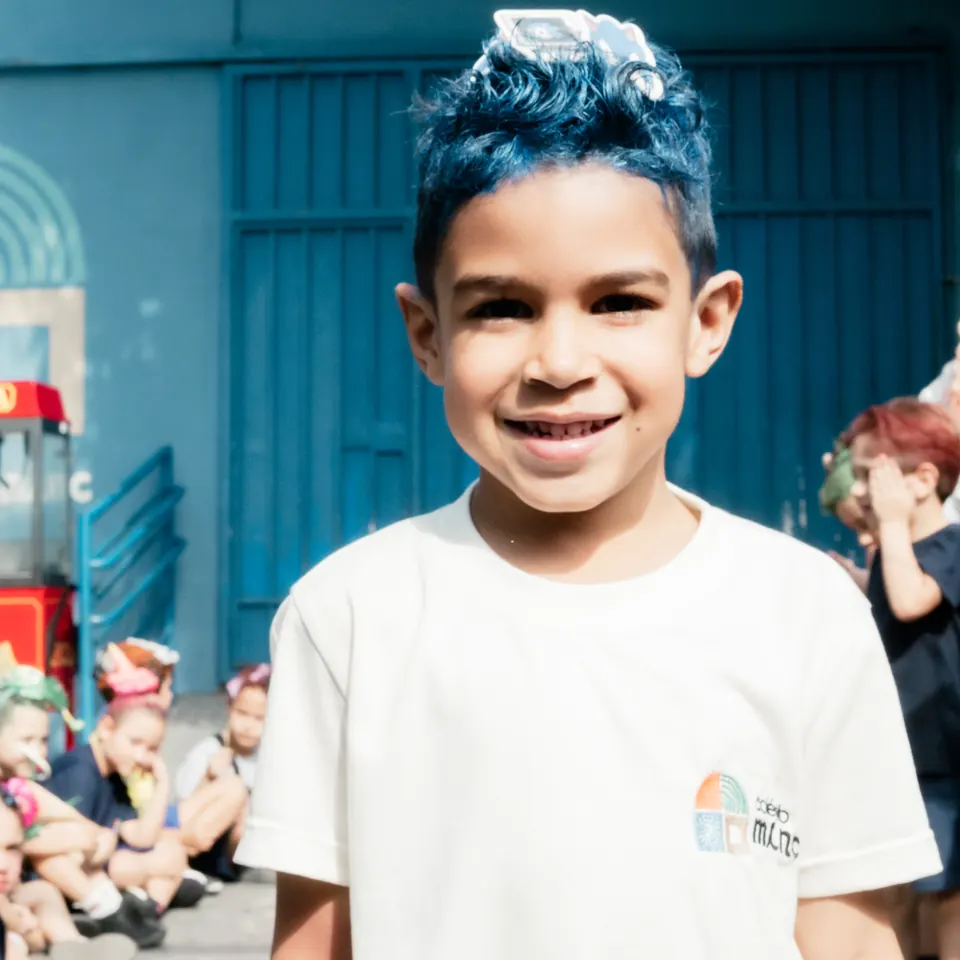 Aluno do Colégio MINC sorrindo com o uniforme