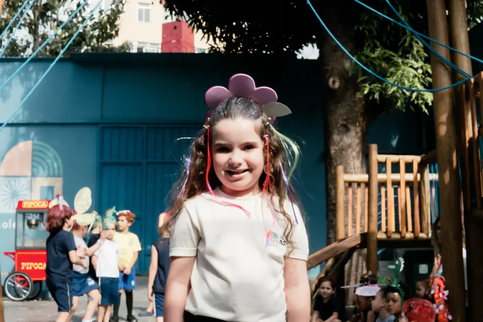 Aluna da Educação Infantil sorrindo no pátio do Colégio MINC