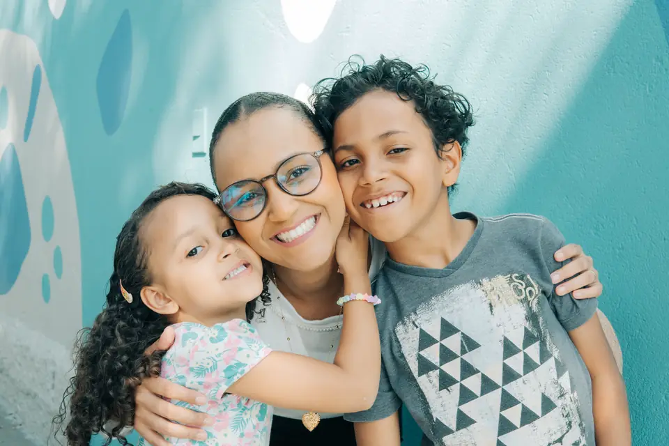 Mãe com os filhos na comunidade do Colégio MINC