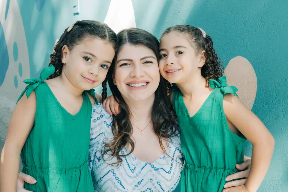 Mãe com as filhas da comunidade do Colégio MINC